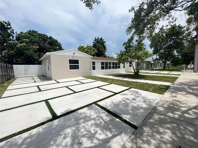 a view of a patio with a table and chairs under an umbrella