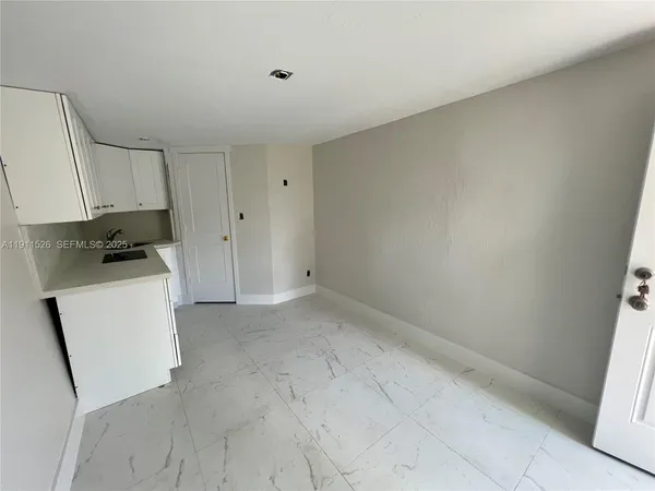 a room with a white cabinets and white appliances
