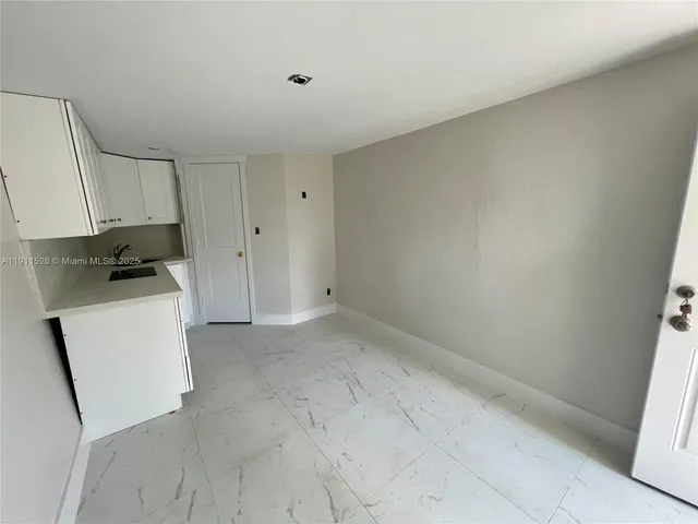 a room with a white stove next to a white cabinet