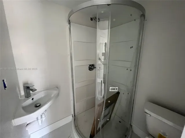 a bathroom with a shower a toilet and sink