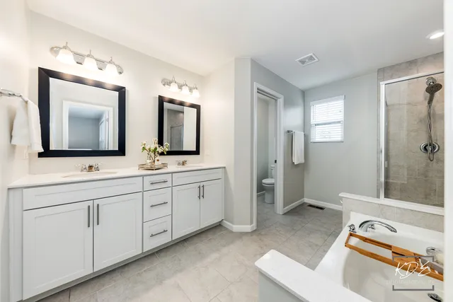 a spacious bathroom with a double vanity sink mirror and double