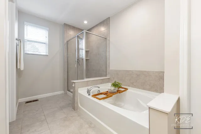 a bathroom with a tub sink and mirror
