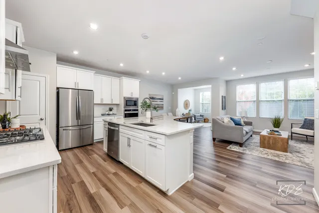 a large kitchen with stainless steel appliances lots of counter space and wooden floor