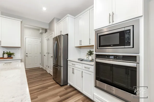 a kitchen with granite countertop a stove microwave and refrigerator