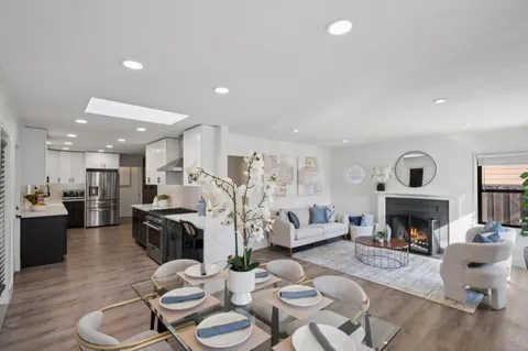 a living room with furniture kitchen view and a fireplace