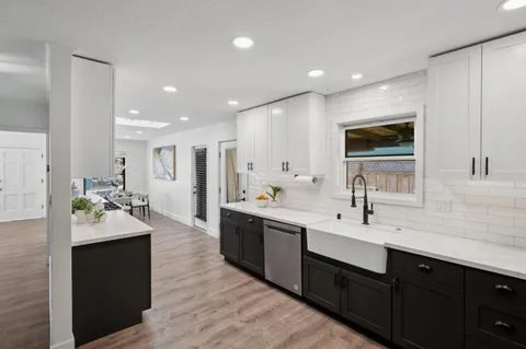 a large kitchen with a sink and cabinets