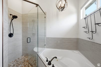 722 West Webb Circle, Unit 2 Draper, UT 84020 - Photo 15 of 39 Corner soaking tub, glass-enclosed shower with pebble-tile flooring, and a rainfall showerhead