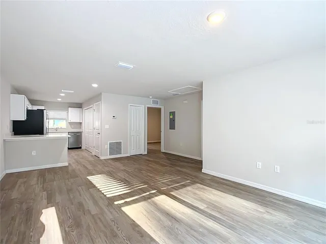 a view of a big room with wooden floor and windows
