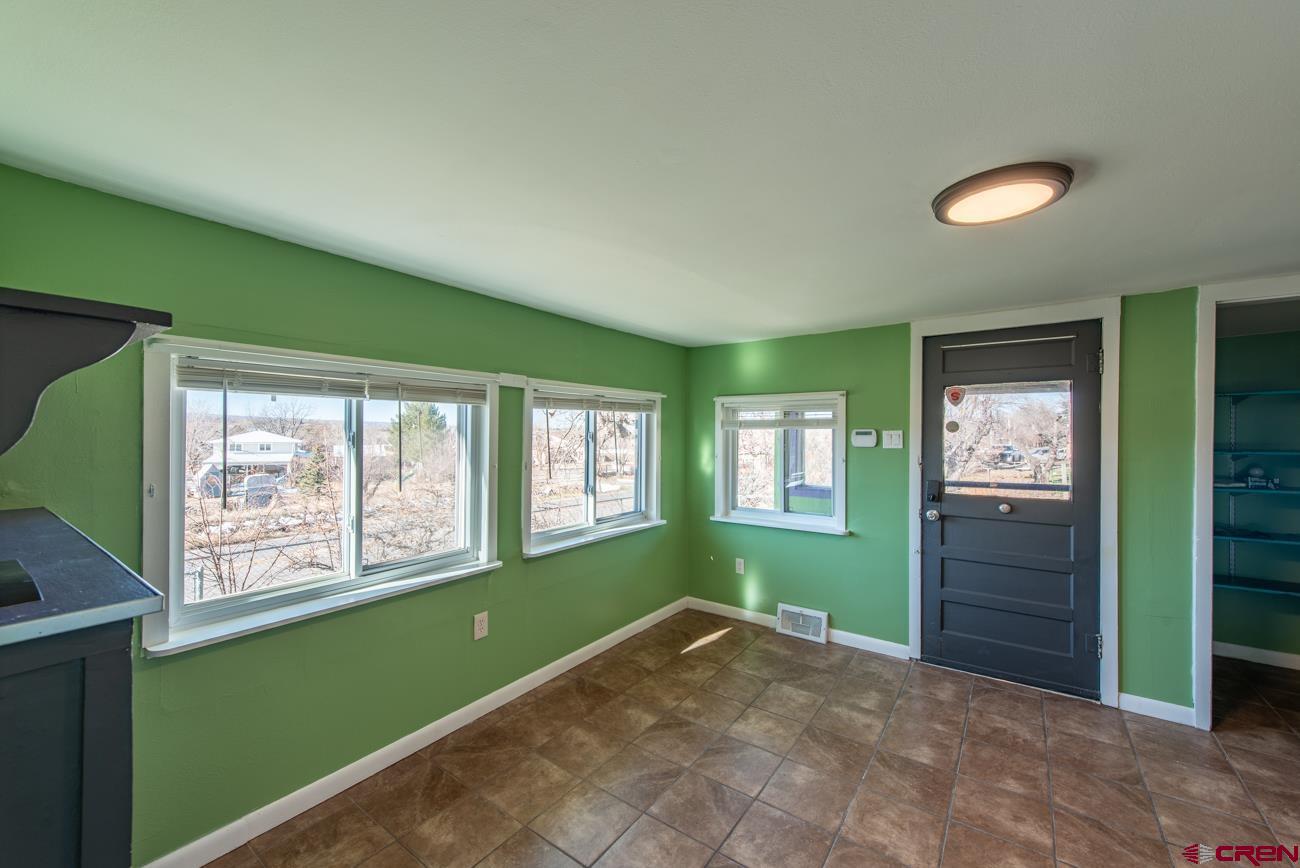 16322 Chipeta Road Montrose, CO 81403 - Photo 10 of 42 a view of an empty room with a window and wooden floor