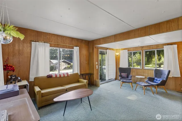 a dining room with furniture water view and a floor to ceiling window
