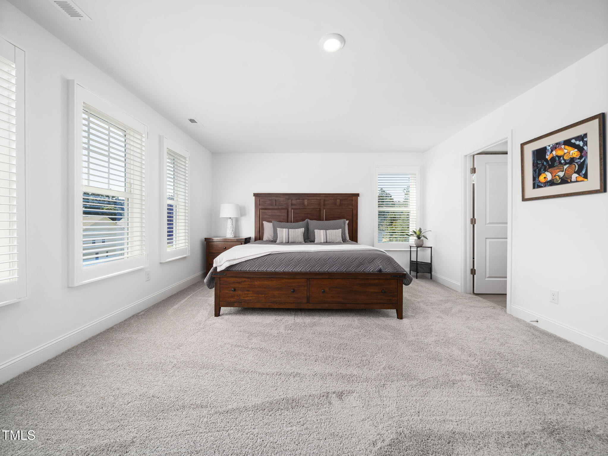1112 Prominence Drive Durham, NC 27712 - Photo 17 of 40 a bedroom with a bed two windows and a closet