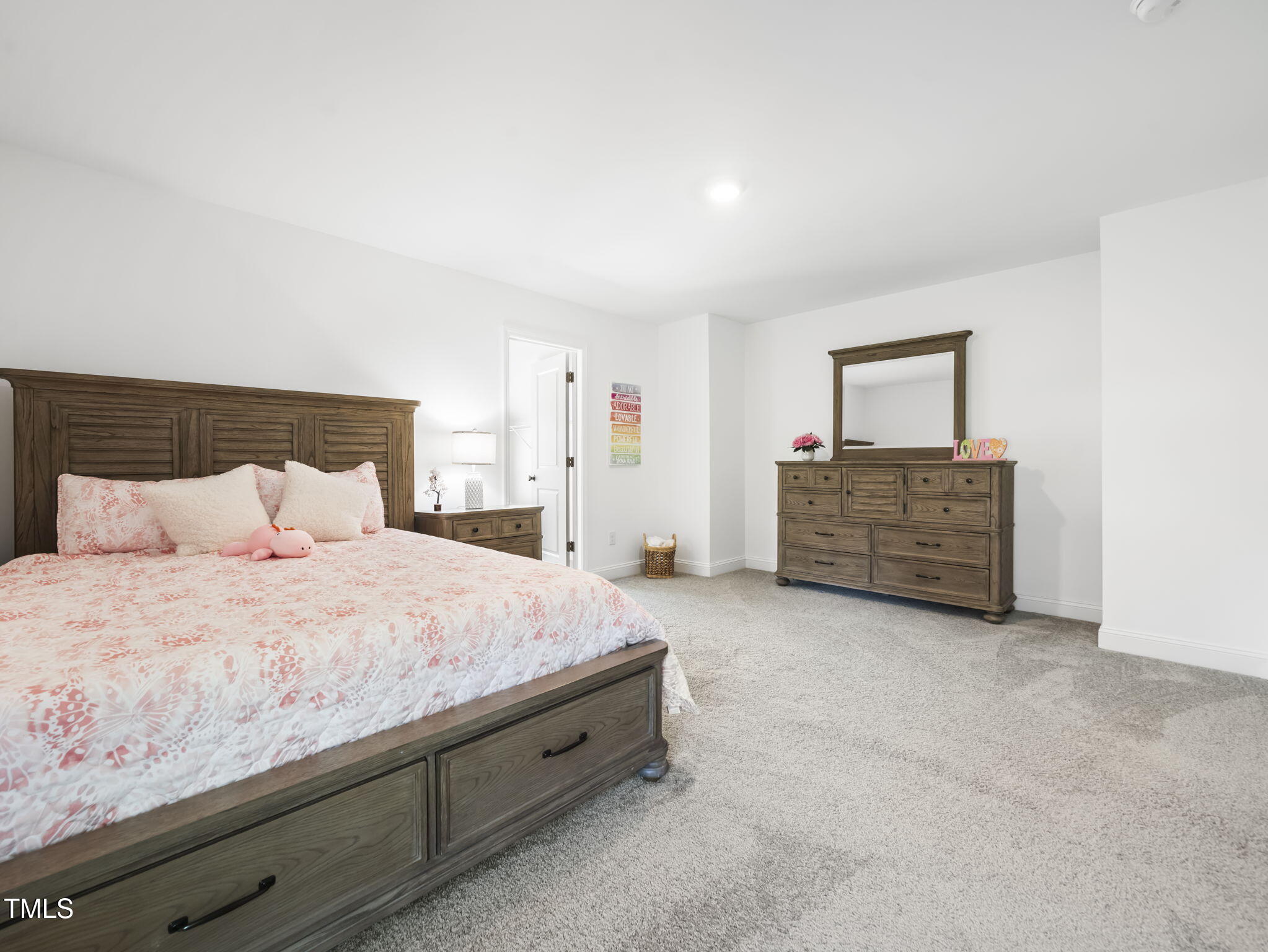 1112 Prominence Drive Durham, NC 27712 - Photo 20 of 40 a spacious bedroom with a bed and cabinet