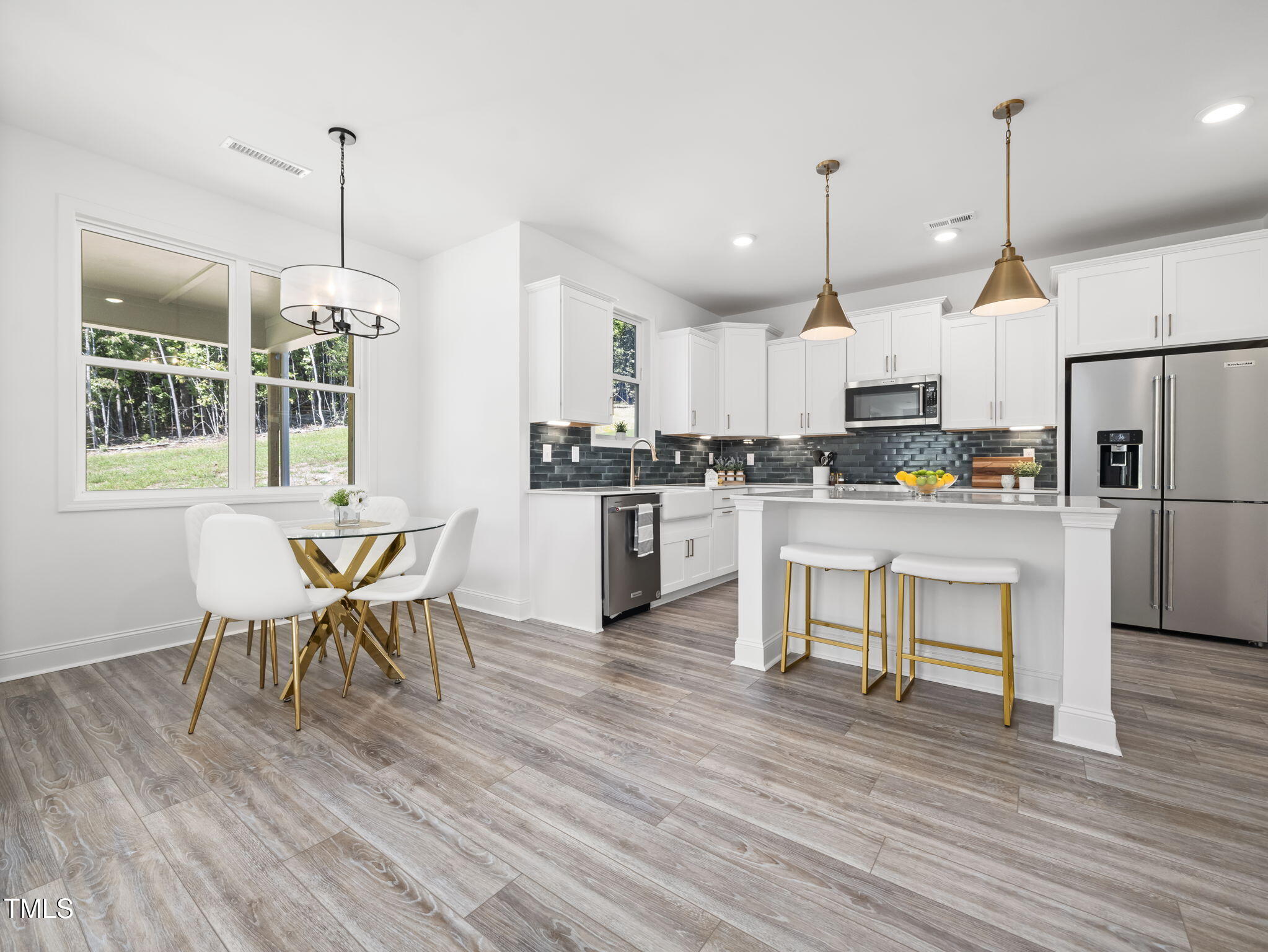 1112 Prominence Drive Durham, NC 27712 - Photo 9 of 40 a kitchen with stainless steel appliances granite countertop a stove a refrigerator a kitchen island a dining table and chairs with wooden floor