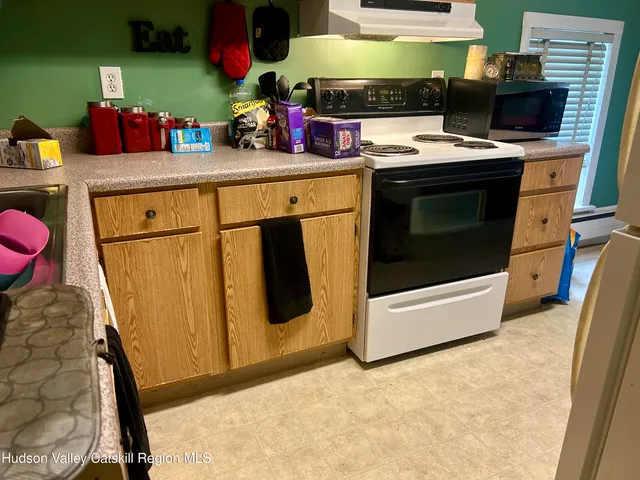 a kitchen with stainless steel appliances granite countertop a stove a microwave a sink and cabinets