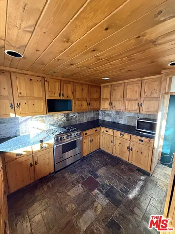 a kitchen with stainless steel appliances granite countertop a sink a stove a counter space cabinets and stainless steel appliances