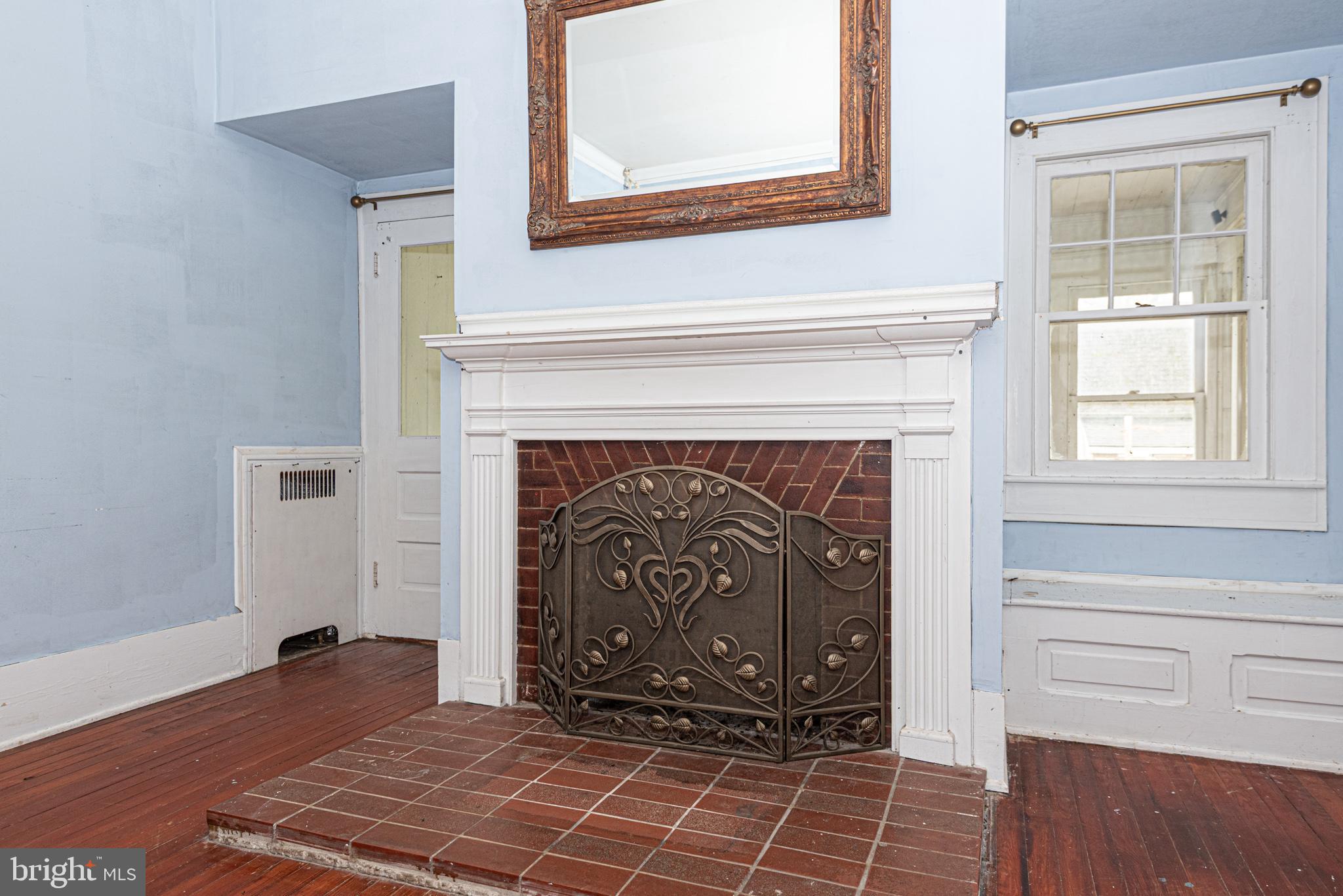 8318 Langmaid Road Newark, MD 21841 - Photo 37 of 122 a view of an empty room with wooden floor fireplace and a window