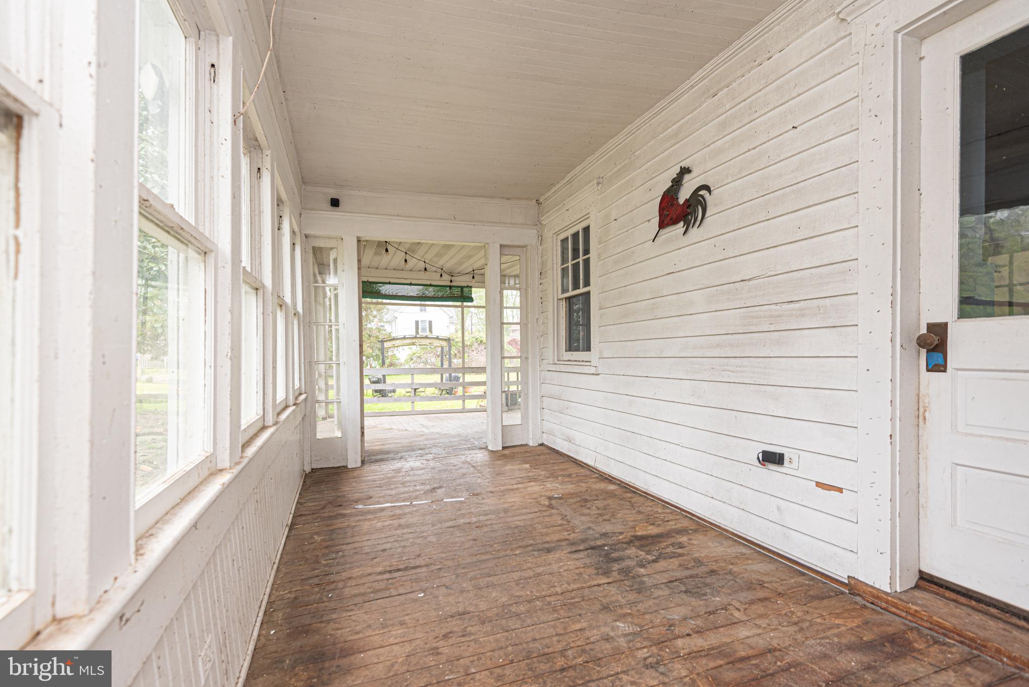 8318 Langmaid Road Newark, MD 21841 - Photo 90 of 122 a view of a hallway with wooden floor and windows