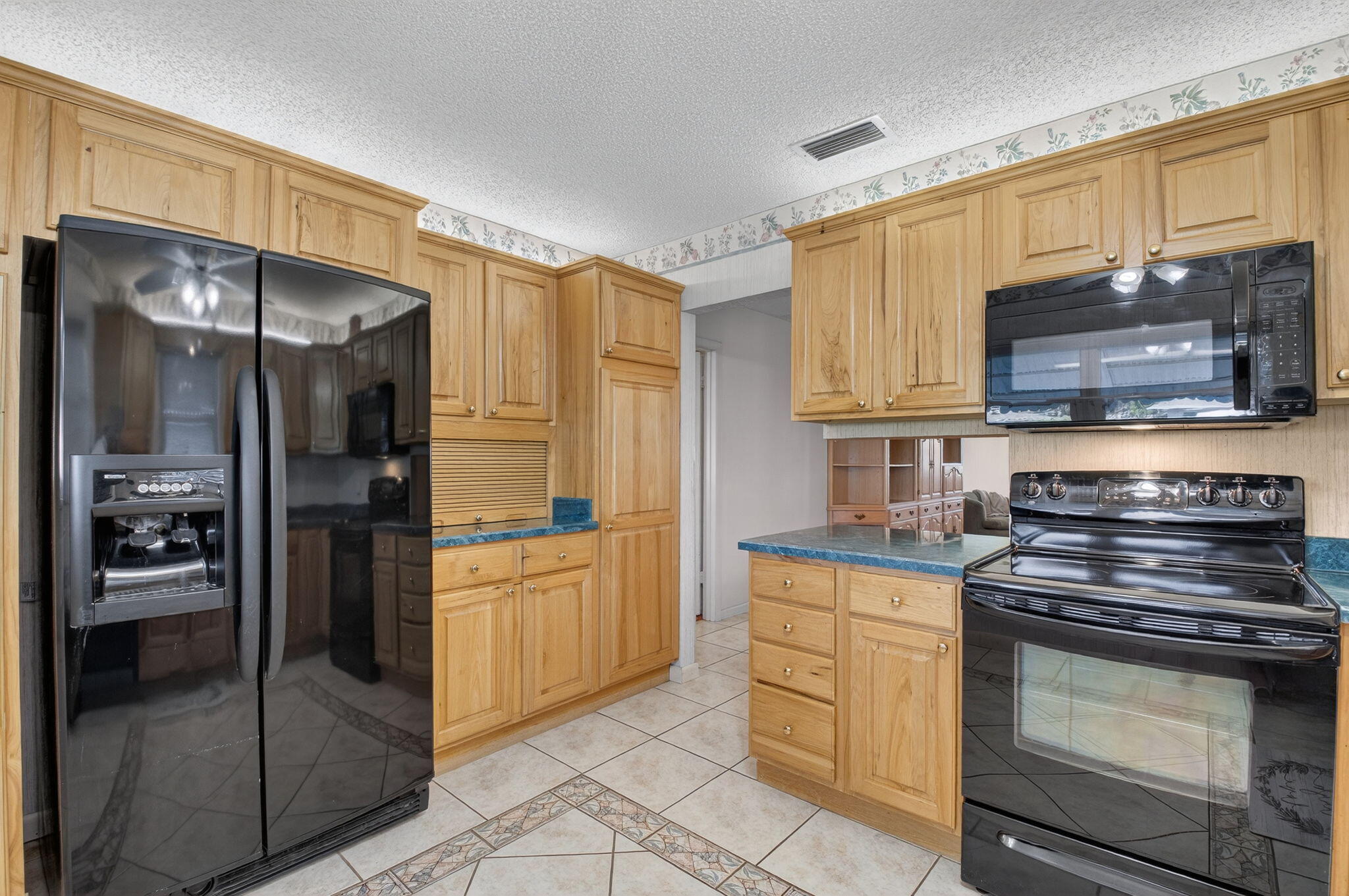 634 Hummingbird Lane Delray Beach, FL 33445 - Photo 16 of 37 a kitchen with stainless steel appliances granite countertop a refrigerator and a stove top oven