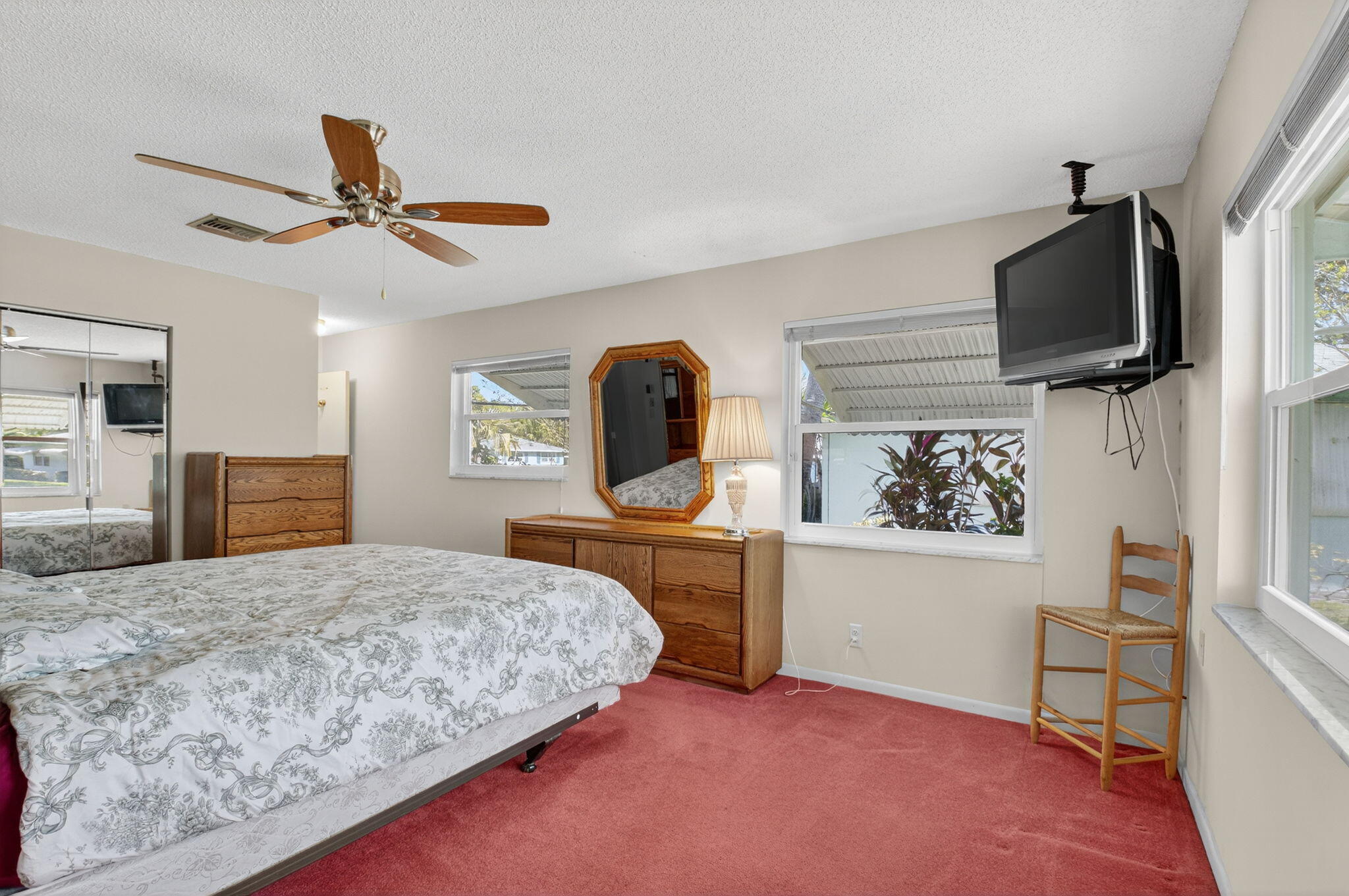 634 Hummingbird Lane Delray Beach, FL 33445 - Photo 22 of 37 a bedroom with a bed a flat screen tv and dresser