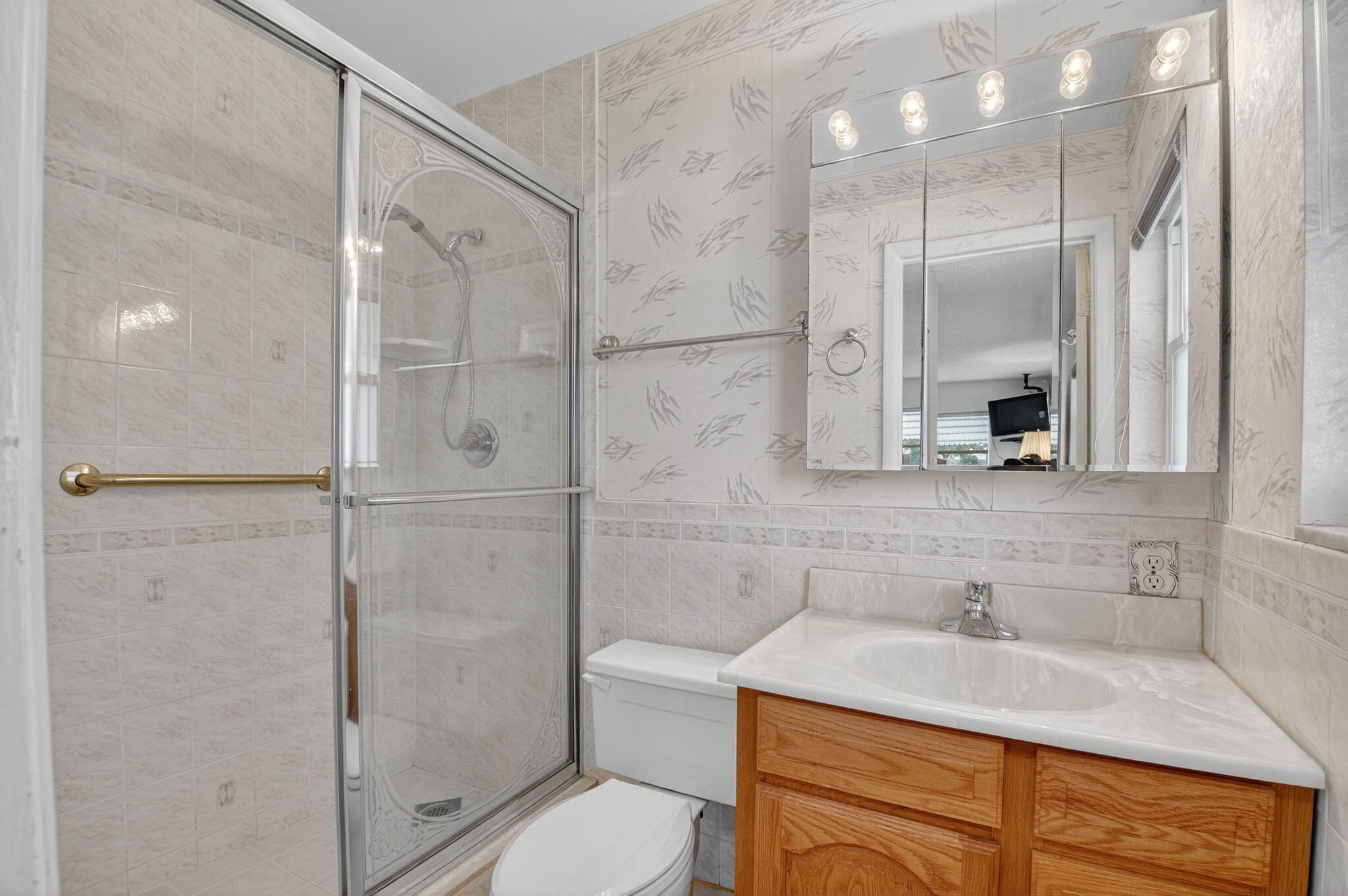 634 Hummingbird Lane Delray Beach, FL 33445 - Photo 24 of 37 a bathroom with a sink shower and a mirror