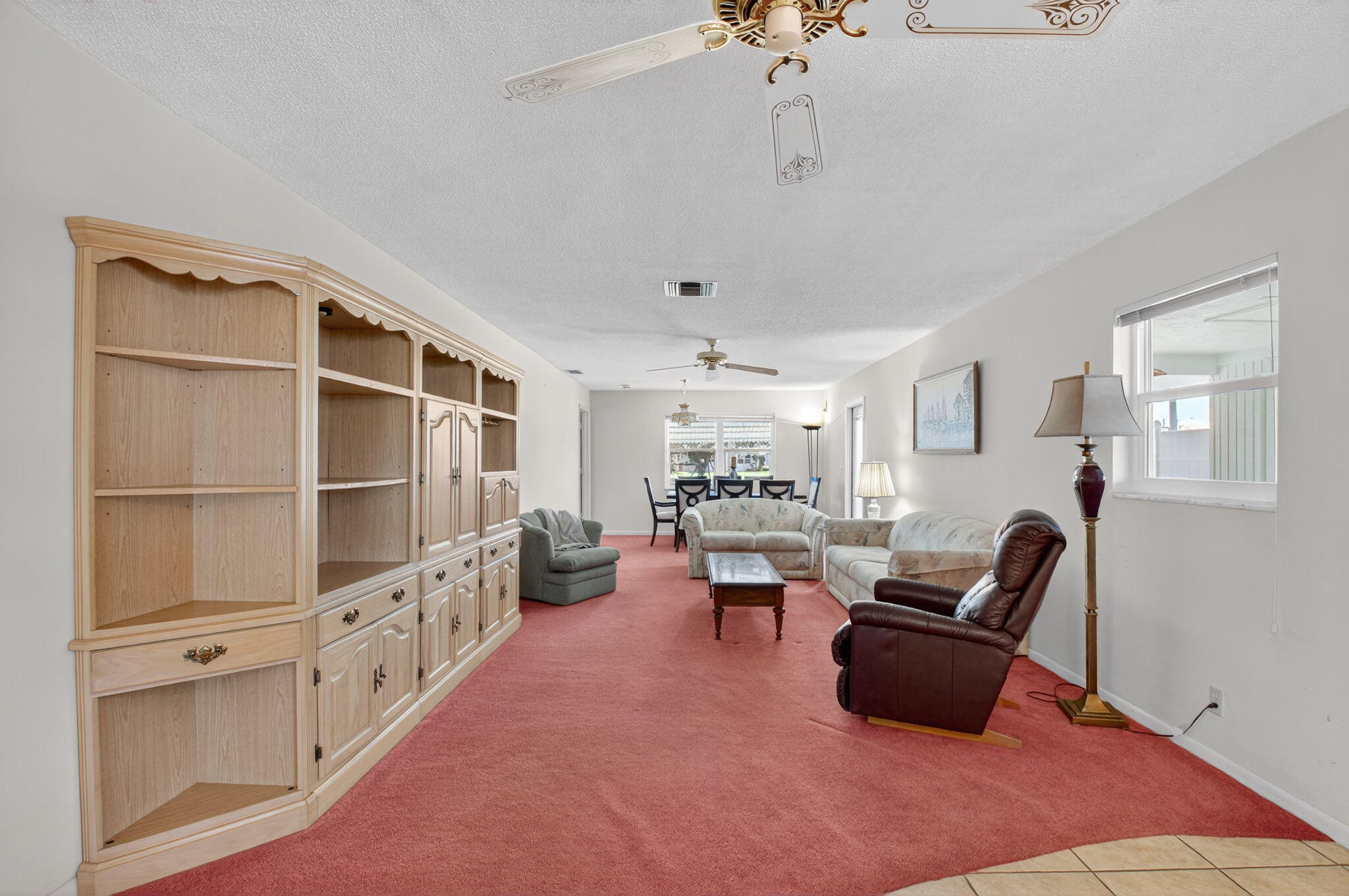 634 Hummingbird Lane Delray Beach, FL 33445 - Photo 7 of 37 a living room with furniture a rug chandelier and a window