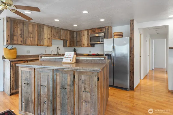 a kitchen with kitchen island granite countertop a sink stainless steel appliances and cabinets