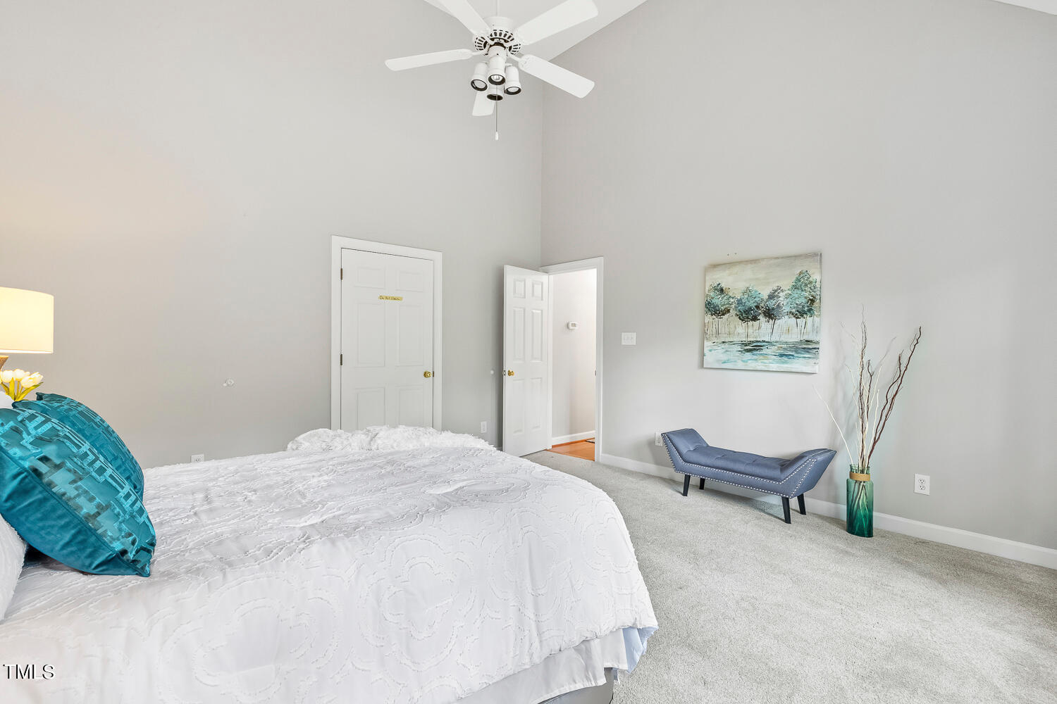 4604 Troone Court Raleigh, NC 27612 - Photo 32 of 54 a spacious bedroom with a bed and a chandelier