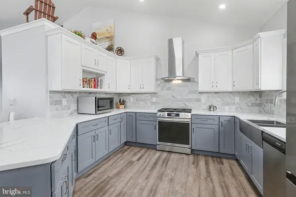 a kitchen with stainless steel appliances granite countertop a stove sink and cabinets