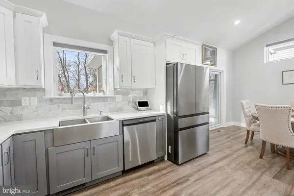 a kitchen with stainless steel appliances white cabinets and wooden floor