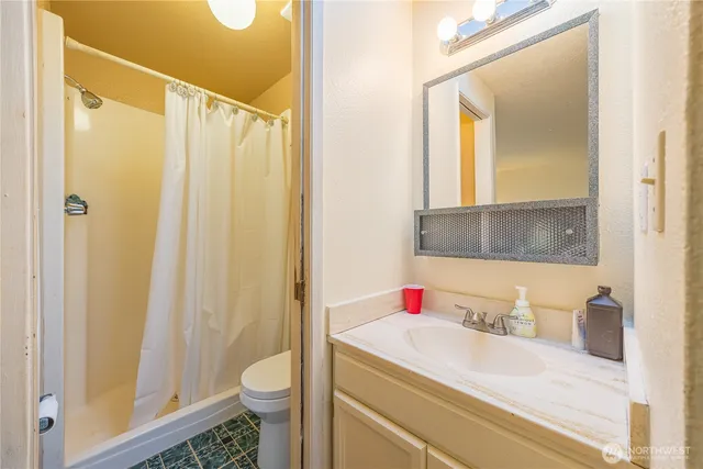 a bathroom with a granite countertop sink toilet and shower
