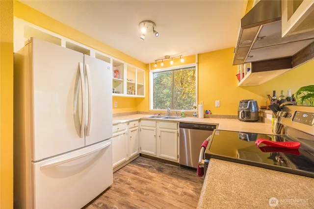 a kitchen with stainless steel appliances granite countertop a refrigerator and a sink