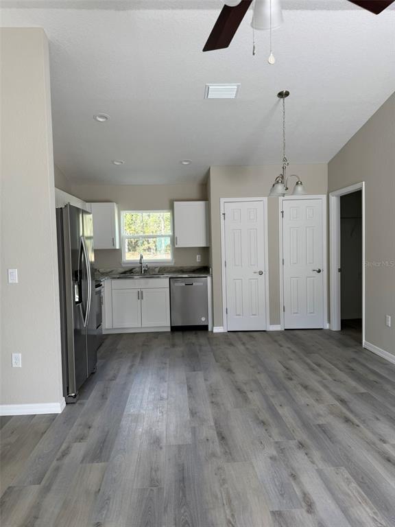 9543 North Travis Drive, Unit B Citrus Springs, FL 34434 - Photo 2 of 11 an empty room with wooden floor and a kitchen