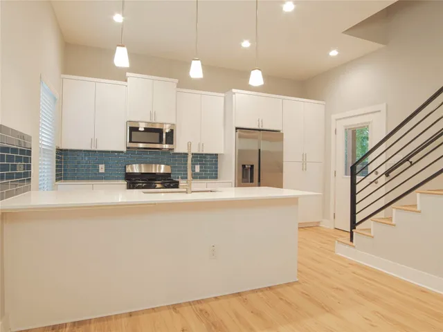 a kitchen with stainless steel appliances a refrigerator sink and microwave