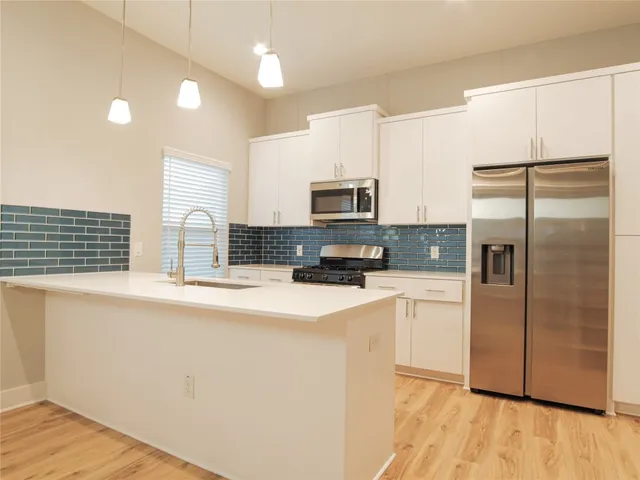 a kitchen with granite countertop a sink stove and cabinets