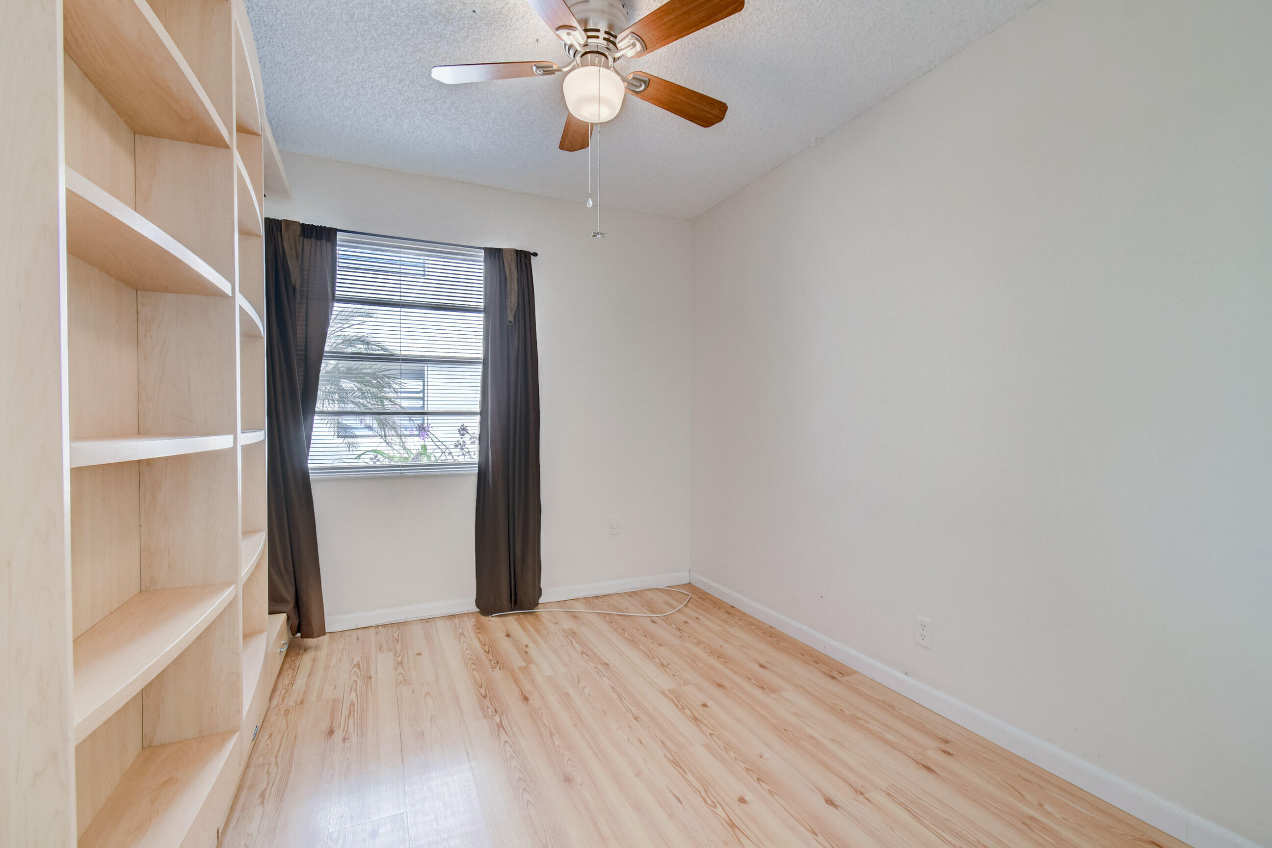 61 Capri B Delray Beach, FL 33484 - Photo 28 of 46 an empty room with wooden floor closet and windows
