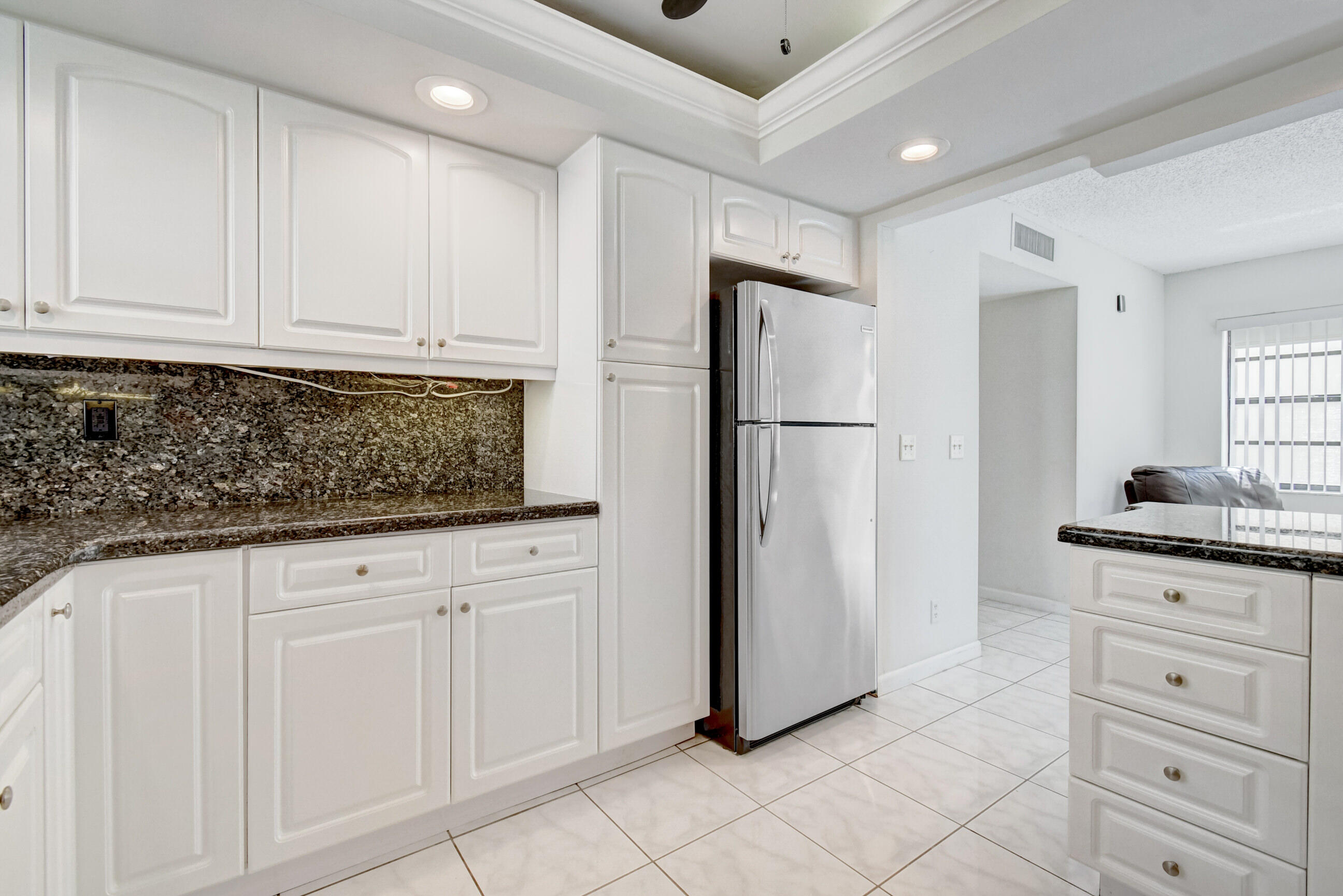61 Capri B Delray Beach, FL 33484 - Photo 8 of 46 a kitchen with white cabinets and refrigerator