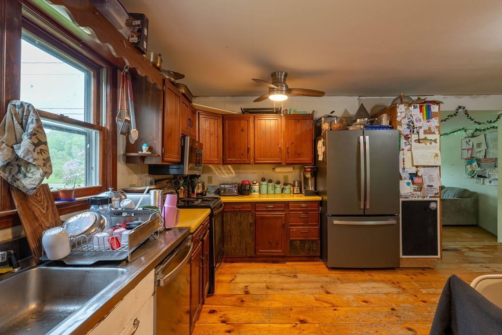 425 Dingle Road Worthington, MA 01098 - Photo 6 of 32 a kitchen with stainless steel appliances granite countertop a refrigerator a sink dishwasher a stove and a dining table with wooden floor