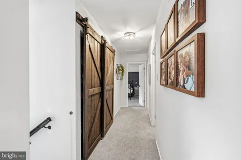 a hallway with wooden floor and stairs