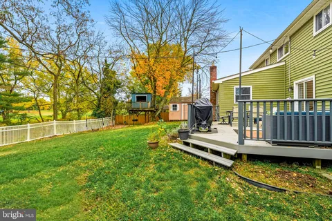 a view of a house with backyard and wooden fence
