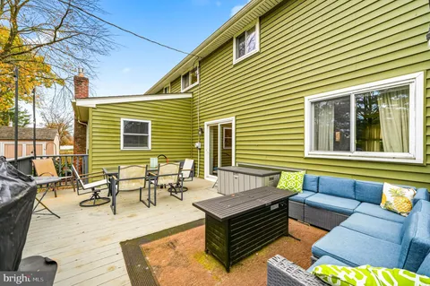 a view of a patio with couches and a dining table and chairs with wooden floor