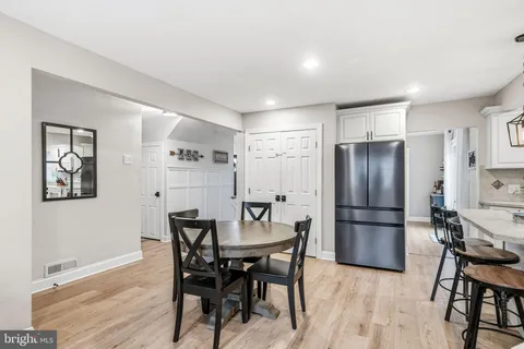 a kitchen with a dining table chairs refrigerator and cabinets