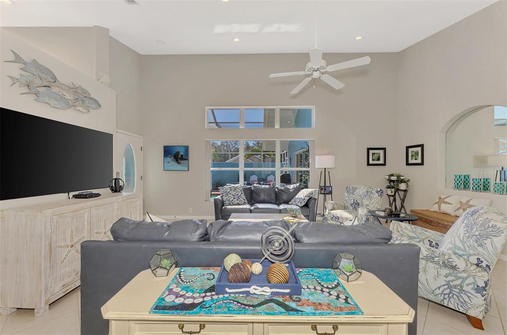 335 St George Court, Unit 1 Venice, FL 34293 - Photo 21 of 87 a living room with furniture a flat screen tv and a large window