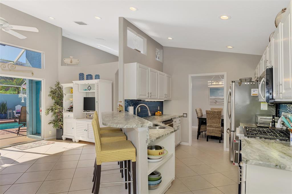 335 St George Court, Unit 1 Venice, FL 34293 - Photo 32 of 87 a living room with stainless steel appliances kitchen island granite countertop furniture and a kitchen view