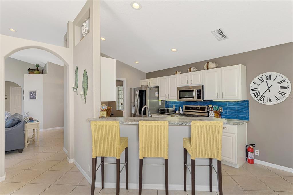 335 St George Court, Unit 1 Venice, FL 34293 - Photo 33 of 87 a kitchen with stainless steel appliances kitchen island granite countertop a table and chairs in it