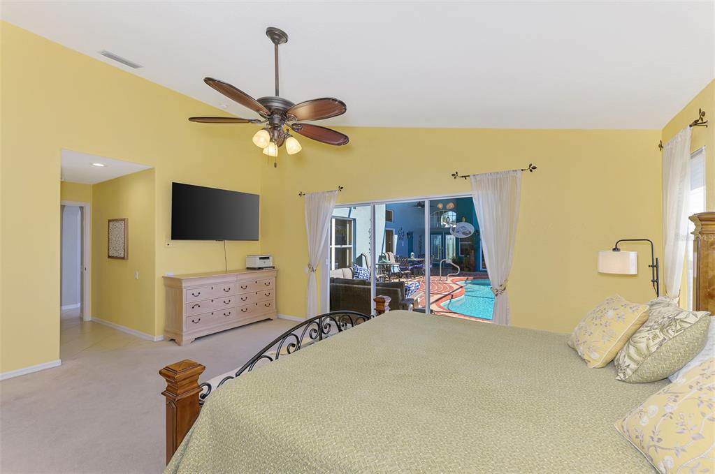 335 St George Court, Unit 1 Venice, FL 34293 - Photo 40 of 87 a bedroom with a bed flat screen tv and a chandelier