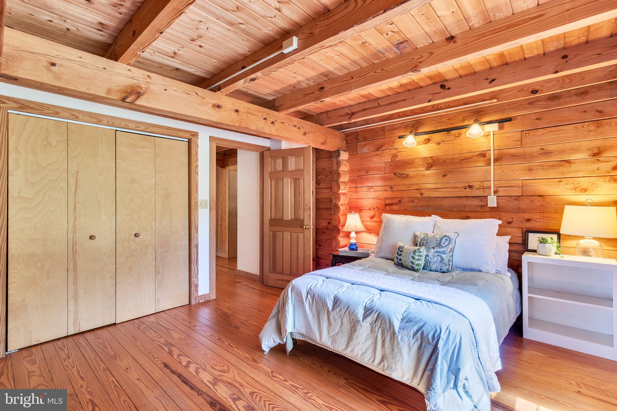 1280 Kelley Neck Road Lancaster, VA 22503 - Photo 25 of 51 a bedroom with a large bed and wooden floor