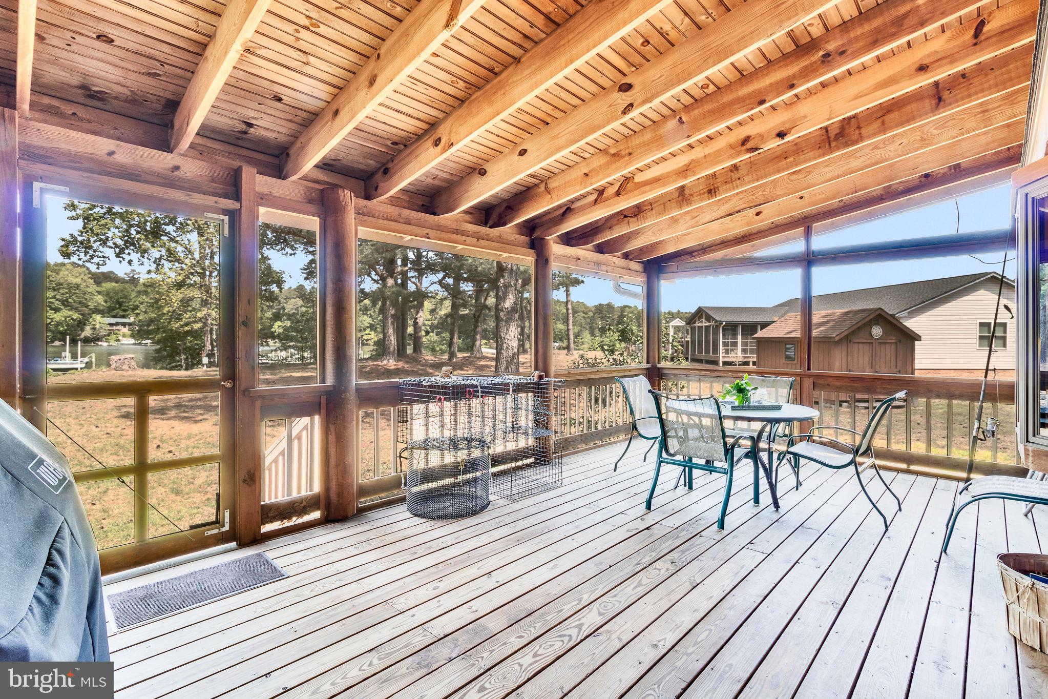 1280 Kelley Neck Road Lancaster, VA 22503 - Photo 33 of 51 a view of a patio with table and chairs and wooden floor