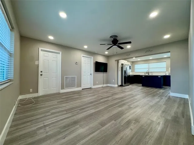 a view of empty room with wooden floor and window