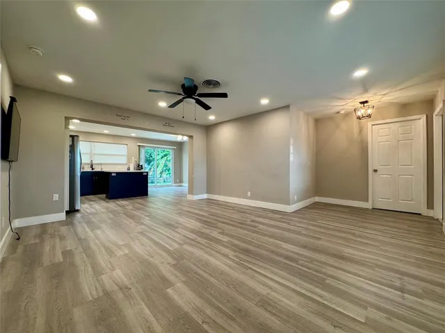 a view of empty room with wooden floor and window