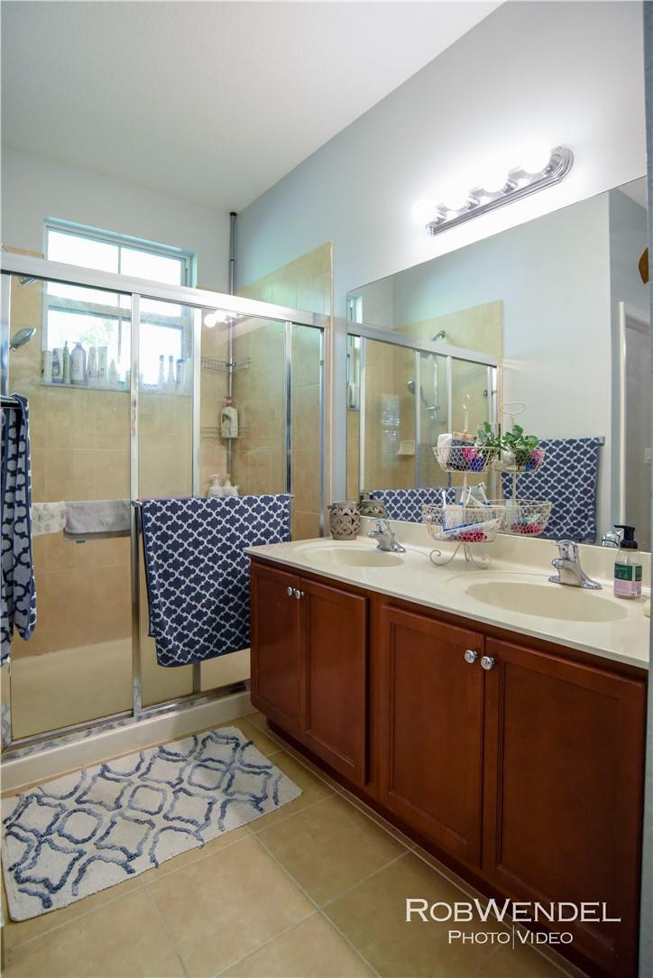 2851 Prospect Road, Unit 405 Tamarac, FL 33309 - Photo 19 of 25 a bathroom with a sink mirror and a shower